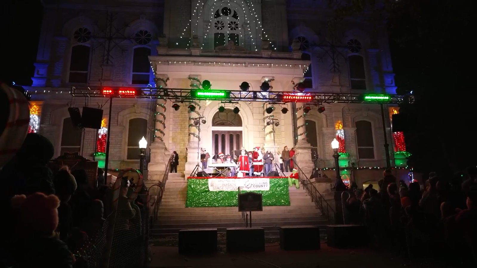 The illuminated Licking County Courthouse above a stage and audience