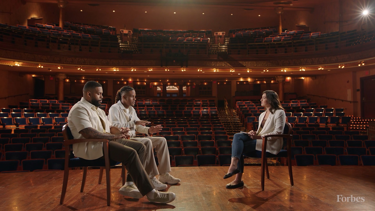 Guests and an interviewer in a theater-stage conversation for Forbes