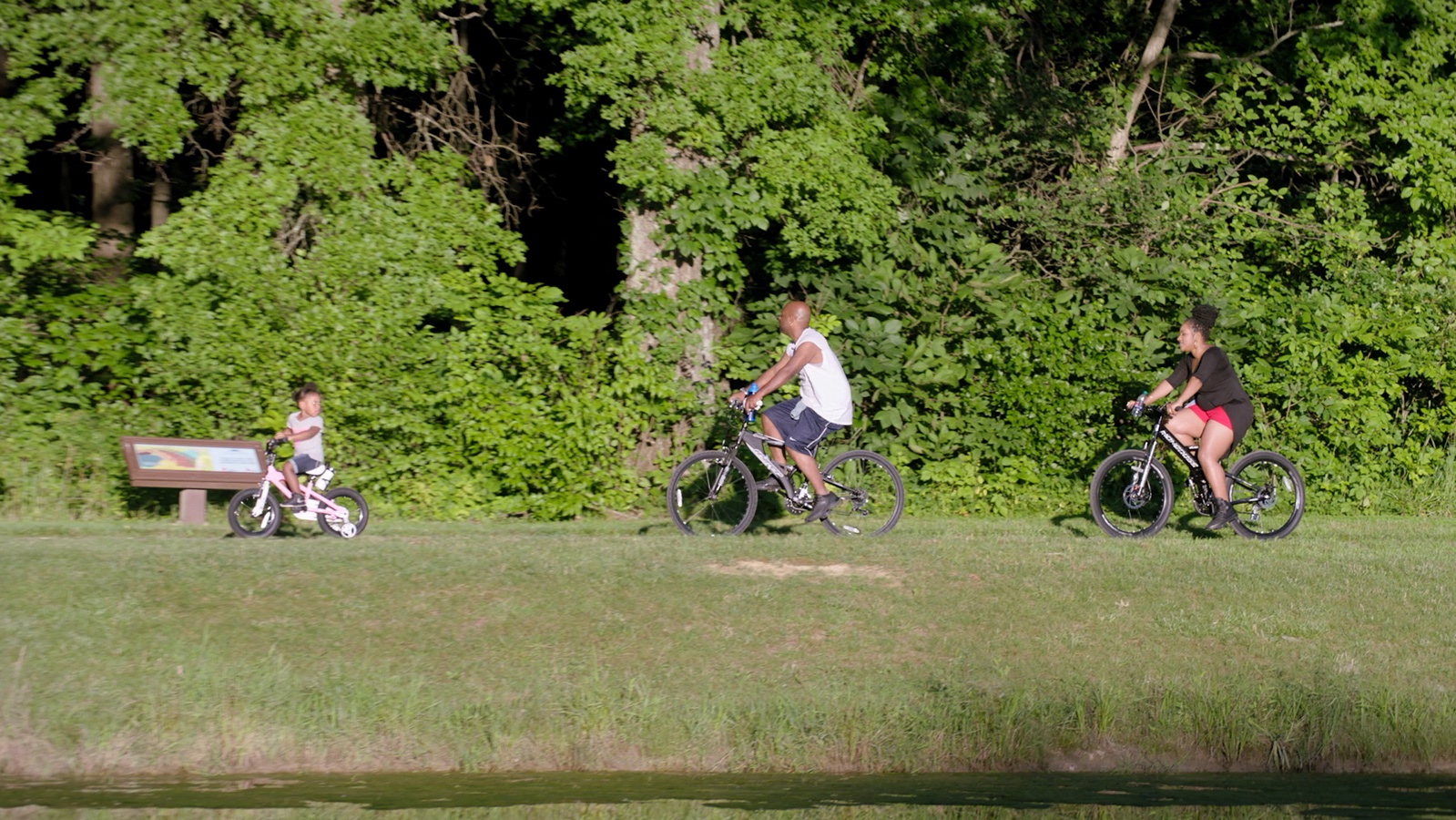 People cycling through a green park in the City of Gahanna brand film