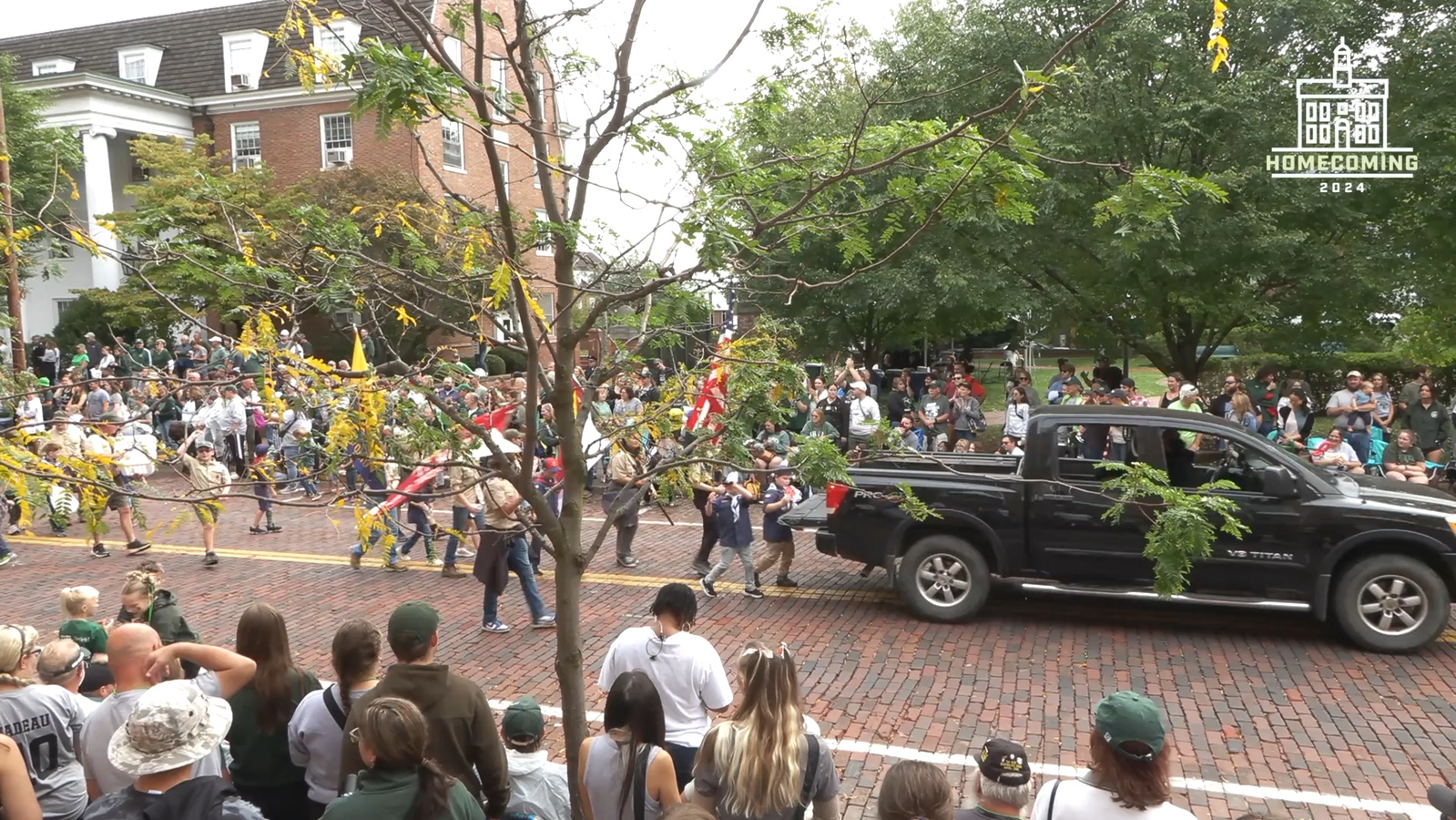Parade participants and spectators filling the Ohio University homecoming route