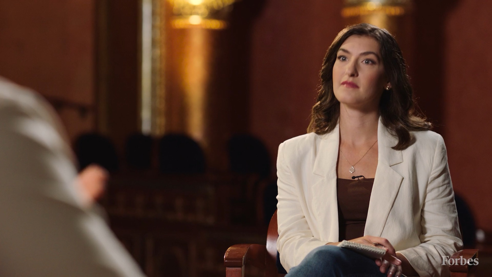 An interviewer on stage during the Forbes 30 Under 30 conversation