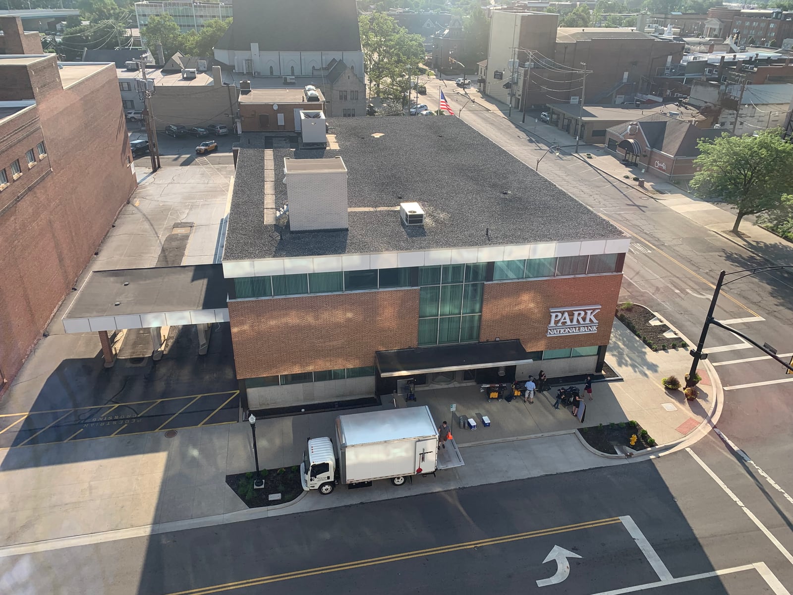 Park National Bank branch exterior with production vehicles and crew during a series shoot