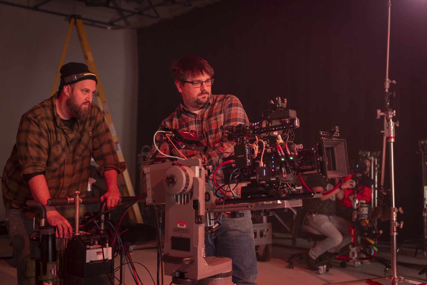 Two crew members working together at a cinema camera rig