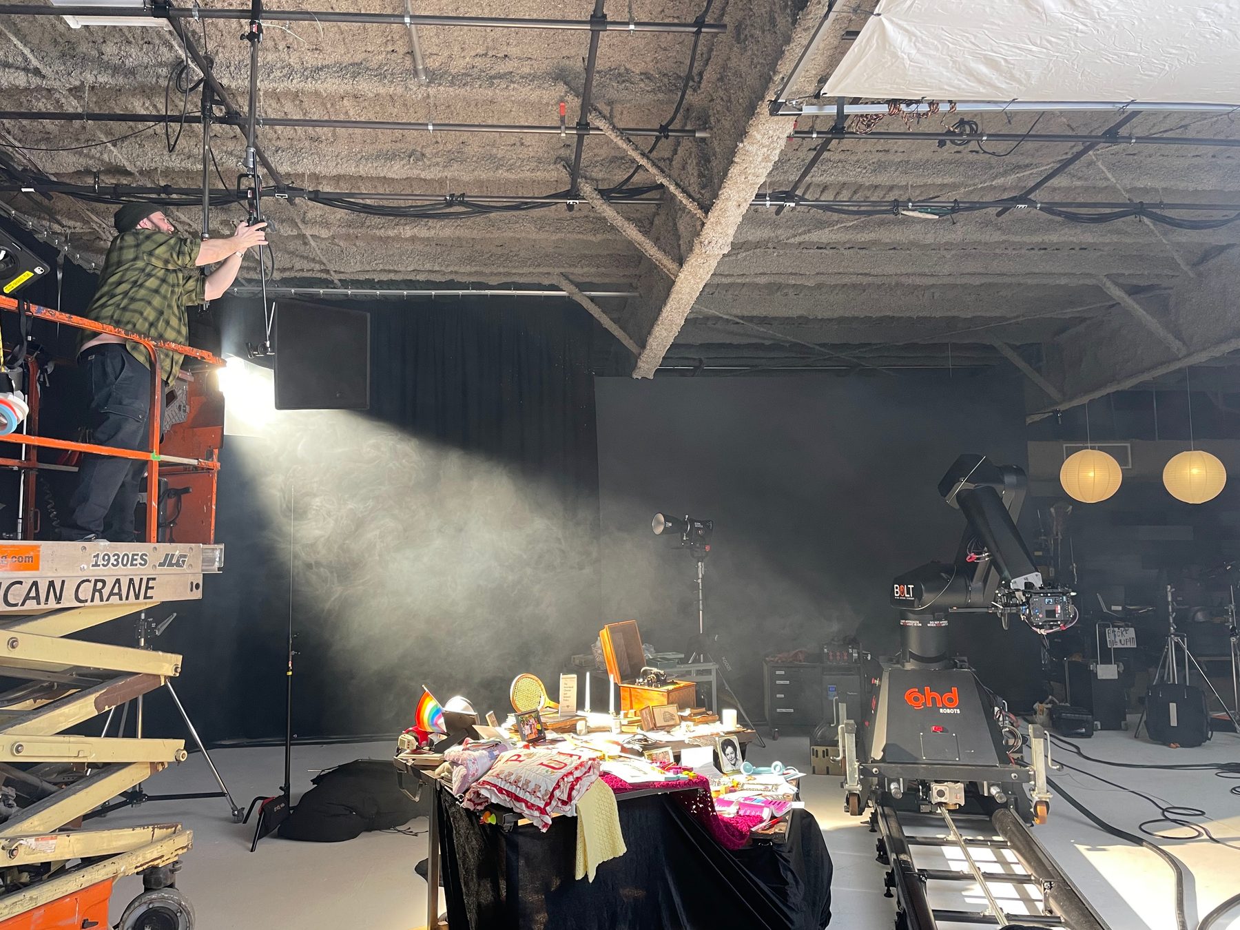 Wide behind-the-scenes view of the YWCA tabletop set, Bolt camera system, lighting and crew