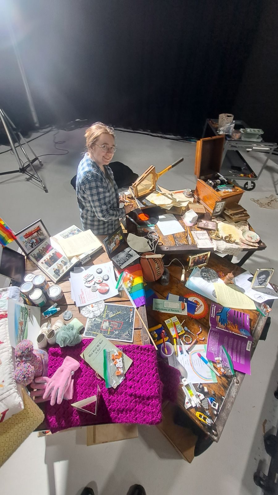 Crew member arranging archival objects on the YWCA tabletop set